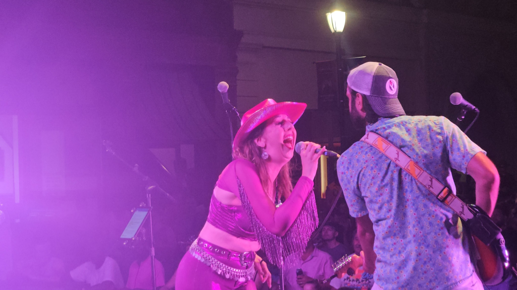 Angela Jan Hunt singing on stage with colorful lights